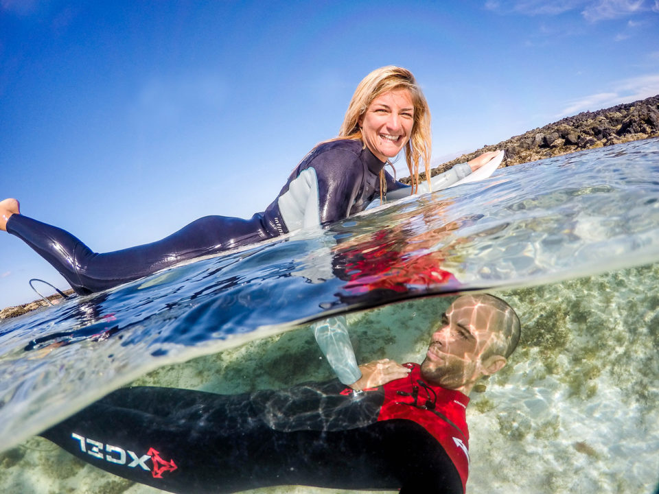 Surf couple having fun in the sea half half photo