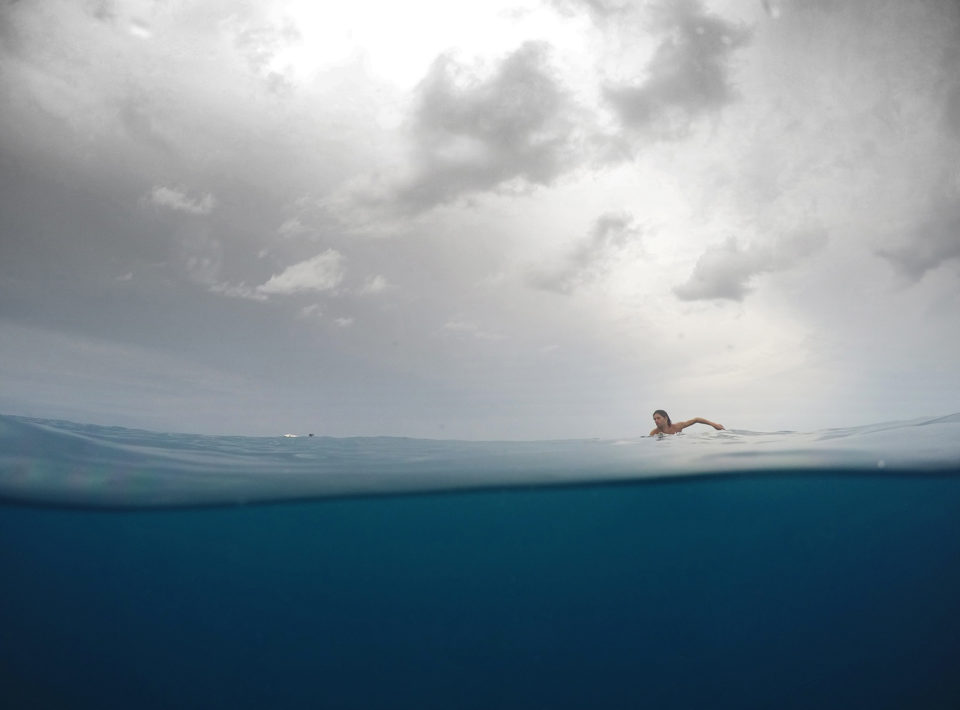 Over under photo of a surfer paddling in Indian ocean