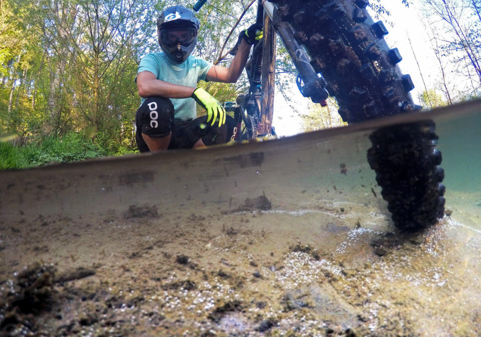 Mountainbiker with his bike in a river half half photo