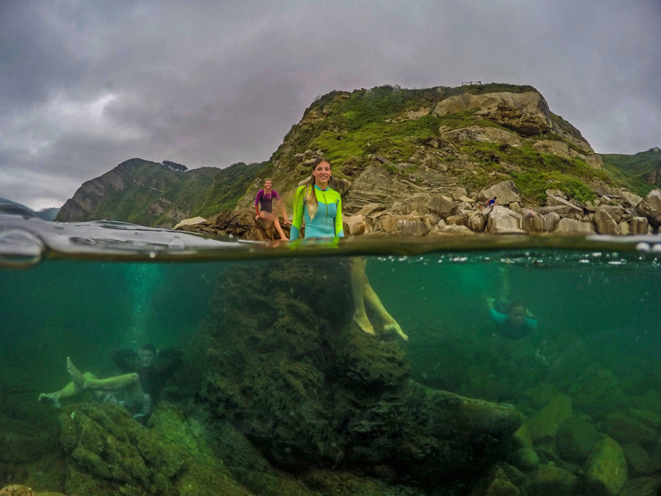 Swimming around rocks in the sea split photo
